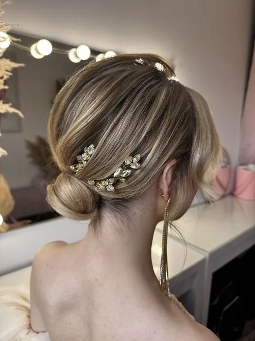 Chignon bas blond, bijoux dorés